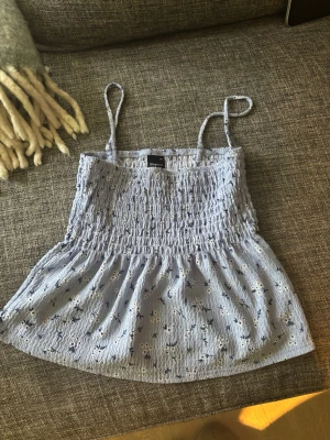 Ljusblå blommig linnetopp Gina Tricot - Supersöt ljusblå linnetopp från Gina Tricot, banden går att ta av och den är även jättefin att bära som kjol💕