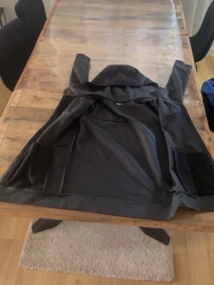 Svart vindjacka från The North Face - Snygg svart vindjacka från The North Face i storlek XL (14/16). Jackan har huva och dragkedja, tillverkad i ett lätt och vindtätt material. Perfekt för blåsiga dagar och enkel att ta med sig. Klassisk design med diskret logga på insidan. Inget fel me den. Priset är 900kr men priser går o diskuteras plus byten går