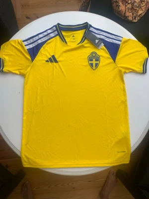 Svensk landslagströja Adidas gul - Gul och blå fotbollströja från Adidas med Sveriges landslagsemblem på bröstet. Säljer tröjan pågrund av att försening. Och nu vill jag inte ha den längre.