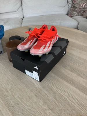 Röda Adidas fotbollsskor med dobbar - Säljer nu mina adidas x crazyfast elite, gjorda för gräs och konstgräs. Skorna är i bra skick förutom att en söm gick upp (det man ser på 3e bilden) Detta är inget som jag märkte av dock när jag spelade med dem. Priset går att diskutera vid snabb affär. 