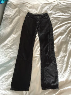 Svarta jeans - Säljer ett par svarta jeans med klassisk femficksdesign och normalhög midja. Jeansen har raka ben som blir något vidare nedtill och är tillverkade i ett mjukt denimtyg. Pris kan diskuteras!