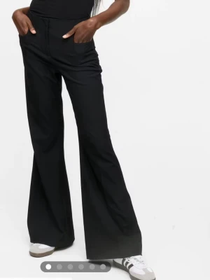 Svarta bootcut kostymbyxor - Snygga svarta kostymbyxor med bootcut. Byxorna har klassiska fickor fram och stängs med dragkedja och hyska.  Använda 2 gånger . Köpt för 600kr på bikbok säljer för 450