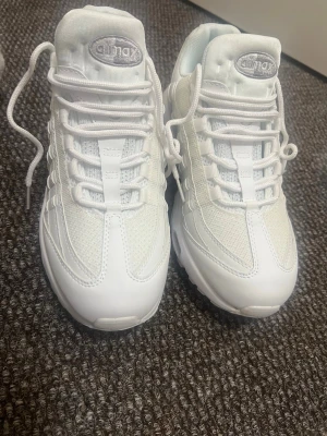 Vita Air Max 95 strl 43 - Fräscha vita Nike Air Max sneakers med klassisk chunky sula och meshpaneler för extra andningsförmåga. Snygga detaljer och broderad Air Max-logga på plösen. Perfekta för dig som gillar en clean och sportig look.