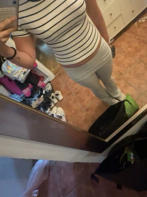 Randig vit och svart t-shirt - Säljer en vit t-shirt med svarta horisontella ränder och svart kant vid halsen. T-shirten har korta ärmar och en figurnära passform. Perfekt till jeans eller kjol för en enkel och snygg look.