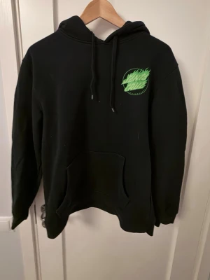 Svart hoodie Santa Cruz  - Svart hoodie från Santa Cruz med tryck på fram och baksida.