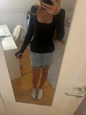Svart långärmad slim topp - Säljer en svart långärmad topp med rundad, djupare urringning. Toppen har en slim passform och är gjord i ett stretchigt material som sitter tajt och snyggt på kroppen. Enkel och stilren modell som är lätt att matcha. Superskönt material!