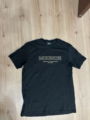 Svart McKenzie t-shirt med tryck - Mått kan skickas vid intresse! Öppen för frågor. Använd 2-3 gånger men som ny!