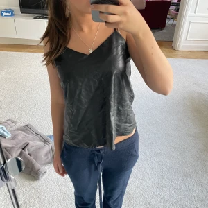 Läder topp - Säljer ett jättefint svart linne i läder från mango!! Aldrig använt! Direkt pris: 260kr