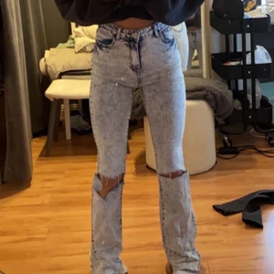 utsvänga jeans - ljus blå utsvänga jeans med hål i knäna 