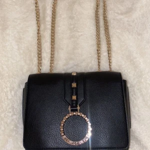 Äkta Versace väska - Säljer min äkta Versace väska i äkta läder, super fin använt några gånger men helt som ny, inga skador eller något på väskan. Köpte den för 2500 kr säljer den för 1500 kr.