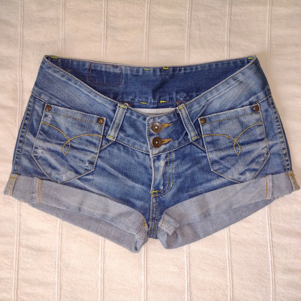 Korta blå lågmidjade jeansshorts från Blue Blue. Så snygga! Med slitningar och dekorativa sömmar. 100% bomull. Storlek 28. . Shorts.