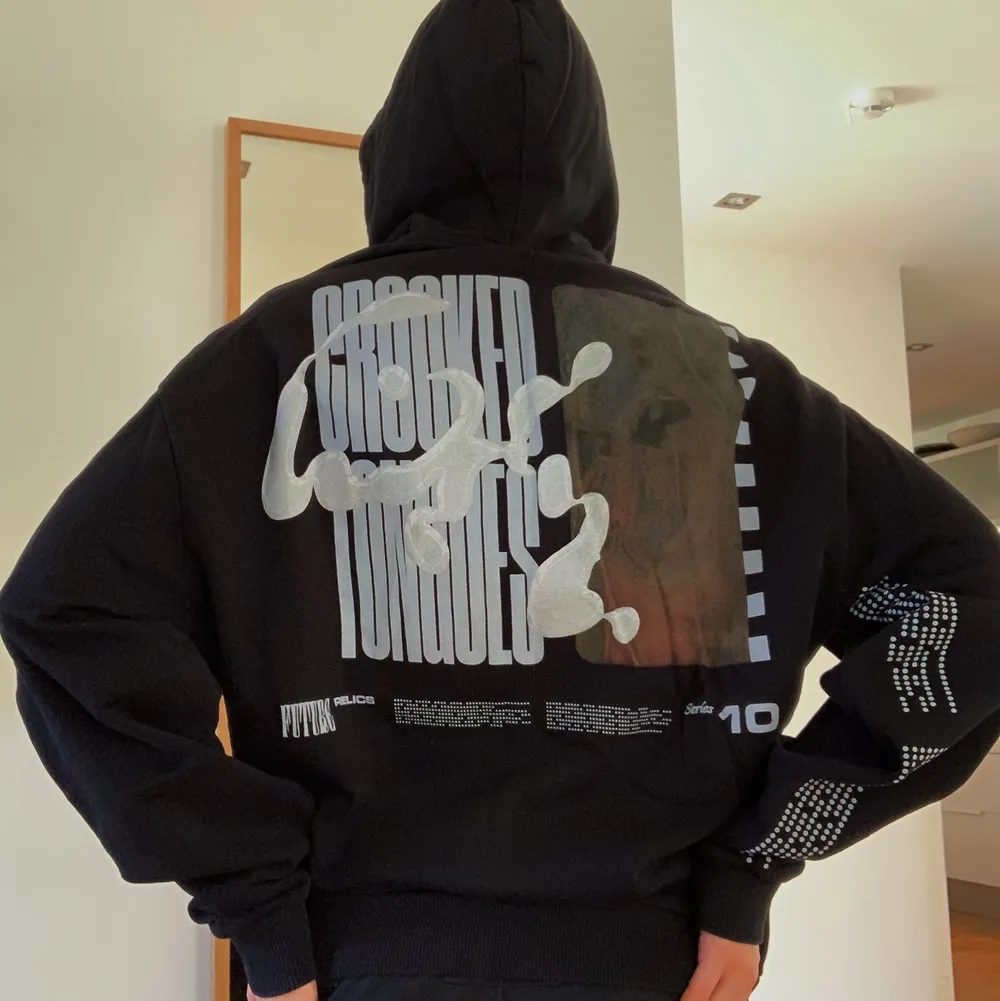 svart hoodie med tryck från crooked tongues! köpt på asos för ca 2 år sedan så tröjan är slut i sortimentet. använd fåtal gånger och i nyskick. kontakta mig för frågor. priset kan diskuteras!. Hoodies.