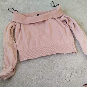 Rosa långärmad tröja i storlek xs som visar axlarna.  
