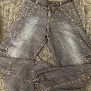 Vintage jeans från 90 talet. Den har många fickor och gummi mand längst ner på byxorna. De har bara andvänds några gånger. 