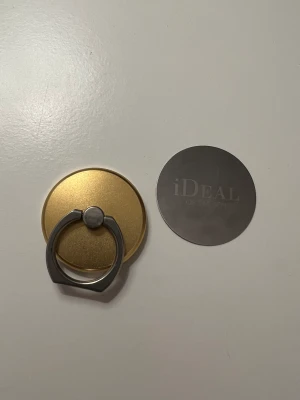 Magnetisk ring från ideal of Sweden  - Säljer en guldig magnetiskt ring från ideal of Sweden. Medföljer även en magnet som man sätter på baksidan av skalet. Nypris 249kr. Säljer för 60kr + frakt. Den är lite slapp och finns tecken av användning så därav priset.