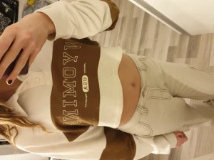 Croppad sweatshirt - En brun och vit croppad swearshirt med tre stycken knappar upptill 