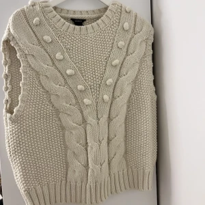 Kofta utan ärmar - En stickad väst från Lindex med fint mönster fram till i storlek S. Säljer för 50kr