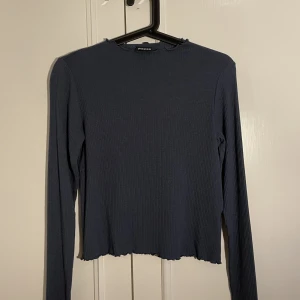 Mörkblå tröja - En mörkblå tröja som är väldigt stretchig och mjuk. Tyget är lite lockat som ni ser på bild 3 uppe på halsen och ärmarna. Använd fåtal gånger. Storlek S