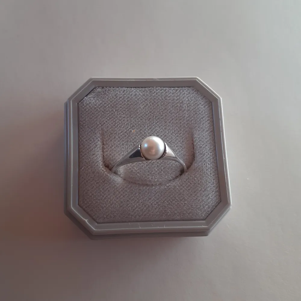 Ring i äkta silver med vit pärla. Mycket fin och i nyskick. Storlek 48 (1,8 cm i diameter) Ask: 10kr (valfritt) Frakt: 15 kr. Accessoarer.