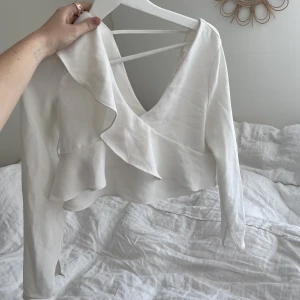 Lånarmand tröja med volanger  - Fin vit lånarmand tröja med volanger. Använd fåtal gånger. Köparen står för frakten :)