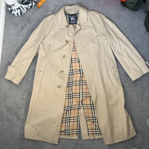 Burberry Rock NK edition   - Beige Burberry monogram trenchcoat  Sällsynt Nordiska Kompaniet limited edition collaboration   Uppsydd (passar storlek M - L)  100% autentisk  Kan mötas upp i Stockholms området eller shippa. 