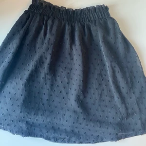 Svart volang kjol - En svart kjol med små prickar och en volang detalj upptill. Från hm i stl 34💙