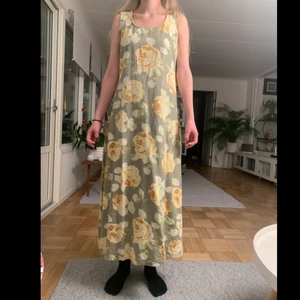 Rabalder sommar klänning  - Härlig maxi klänning från Rabalder med gula rosor på grön bakgrund. Den är gjord i linne tyg, vilket gör den lätt och luftig på varma sommar dagar. Klänningen är ursprungligen från en kollektion 2002, men trots det i mycket bra skick. 