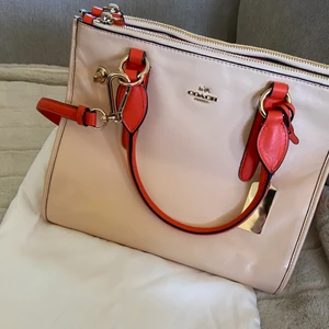 Coach väska - En mellanstor och jätterymlig Coach väska köpt i New York! Dustbag medkommer och kvitto finns. I en ljusorange/mörkorange färg superfräsch till våren! Helt oanvänd, endast legat i påsen under några år. Skriv för mer info/bilder