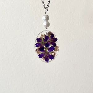 Handgjort Halsband - Handgjort halsband på Omärkt silverkedja! Smycket är dubbelsidigt, så två olika slags självplockade blommor syns! Ena sidan har rosa praktspirea, även kallad ”little princess” 🪷 och andra sidan är midsommarblomster, även kallad skogsnäva 🌸