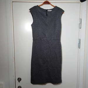 Grå klänning - En grå mönstrad klänning med dragkedja i ryggen. Den har en underklänning i svart sidenlikt material. storlek M🌿