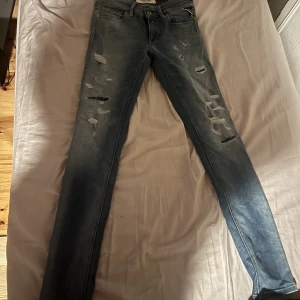 Lågmidjade Jeans - Lågmidjade Jeans från Replay. Snygga slitningar här och där.