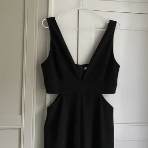 Byxdress från Gina Tricot - V-ringad jumpsuit med cut outs i sidan från Gina Tricot. Säljer då den är lite stor för mig upptill.