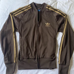 Adidas zip up brun - Säljer min snygga adidas kofta/zip up! Tröjan är i storlek S/36. Den är köpt second hand, men har inga defekter och är i nyskick. Skriv privat om ni är intresserade 😊