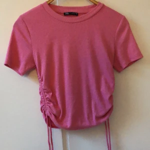 Rosa tshirt  - Rosa tshirt med knyten på sidorna från zara i storlek M. Använd fåtal gånger och i bra skick!