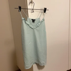 Korallfärgat linne - Linne i en ljusgrön lite korall-färg från Lindex. Jag har kortat banden så den passar någon med mindre byst!