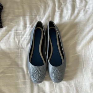 Kenzo ballerina - Kenzo ballerina i storlek 38. De är inte särskilt använda men har en liten repa, se sista bilden. De är ljusblå.