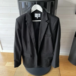 Svart kavaj - Svart kavaj från nakd i storlek 40. Helt oanvänd. På mig som vanligtvis bär S-M har den en oversized fit.