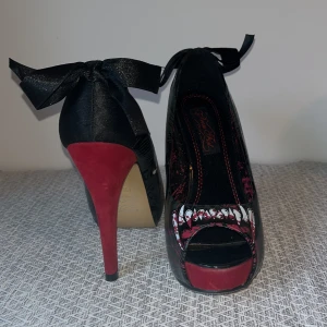 Ladies wolfbeater platform  - Dessa snygga pumps från Iron Fist är så gott som oanvända, 12cm klack, 3,5cm platå. Inga märken eller skav. Material: syntet högblanka och röd sammet samt rosett i syntet. Nypris 800kr 