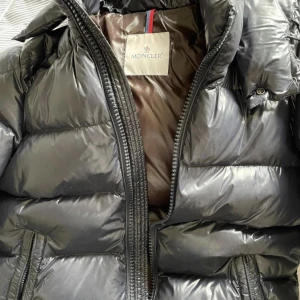 Moncler maya  - Jackan är i väldigt bra skick inga hål varken stora eller små.  Storleken är Size 2 och färgen är svart. Kvitto finns kvar samt medföljer vid köp.  Skriv om du har fler frågor!  Vet att säsongen håller på att ta slut därför anpassar jag mig med priset. 