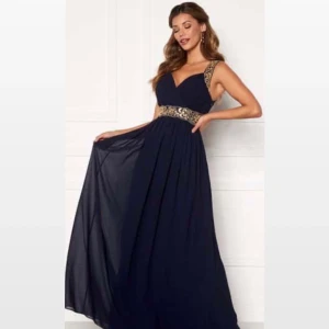 Balklänning marinblå - Säljer fin oanvänd festklänning.  Det är en klänning strl 34 från Chiara Forthi Milano.  Marinblå med gulddetaljer. Pga pandemin blev den inte använd.