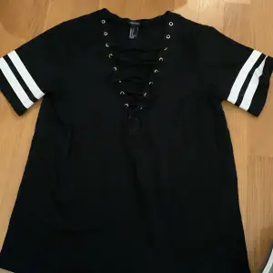 Säljer denna t-shirt med snörning från Forever 21. Storleken är small och tröjan knappt använd :)   Obs! Klicka inte köp nu 