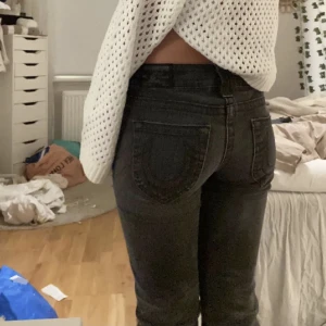 Lågmidjade True Religion Jeans - Hejsan! Säljer nu favvo jeansen då jag ska köpa nya kläder o vill spara lite pengar!🫶🏼Supersöta ÄKTA trueys i svart/grå ton😍Dem är flare nertil! Är 160 o de är långaaaa.W27 men har ett elastiskband i midjan som är stretchigt så passar 32-36!! Jag är en 34🫶🏼