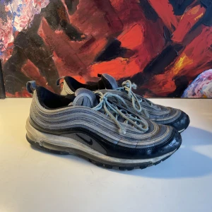 Nike Air Max 97 - Snörena är lite sönder i ändarna och på andra bilden kan man se att reflexen blicit utsliten på vissa ställen annars är allt som det ska. Går nog att göra rent det vita partiet mer än vad jag lyckats med. Kosta 2200kr som nya