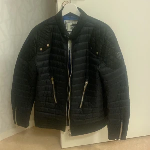 Colmar Jacka Svart - En svart Colmar Jacka helt oanvänd och i mycket fint skick. Cobaltblå på insidan. Modellen är anpassad för både höst- och vårsäsong. Samt har djupa, rymliga fickor på ut-och insidan. 