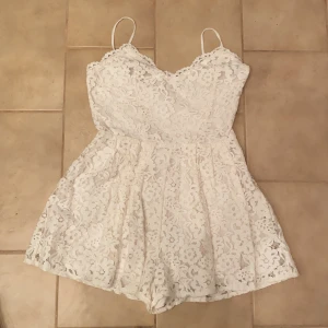 Vit spets romper  - Aldrig använd vit spets romper med spaghetti straps som går att justera vid behov. Jättefin för sommaren eller studenten!! Säljer då den inte kommit till användning, den har aldrig blivit använd. Skriv gärna vid intresse!❤️❤️