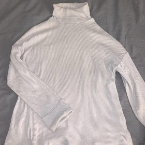 Stickad polo - Vit tröja med högre krage. Strl L men passar även M då den är lite större. Säljer då jag inte använder den och den har inga hål eller missfärgningar. 