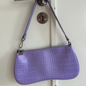 Lila väska  - Oanvänd väska i lila krokodilmönster 