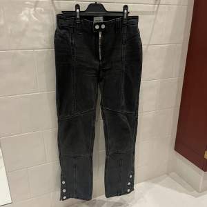 Unika Svarta jeans från Weekday med lappteknik och knappar nedtill som går att knäppa och knäppa upp till en mer bootcut modell. Sitter supersnyggt! Bra skick. Storlek 36. Skriv för fler bilder!