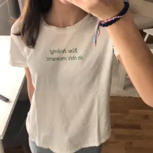 Jätte fin enkel vit T-shirt med en grön text från Gina tricot
