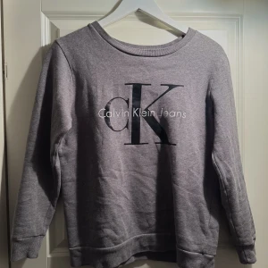 Calvin Klein tjocktröja - Grå Calvin Klein tjocktröja med tryck. Ny i storlek xs